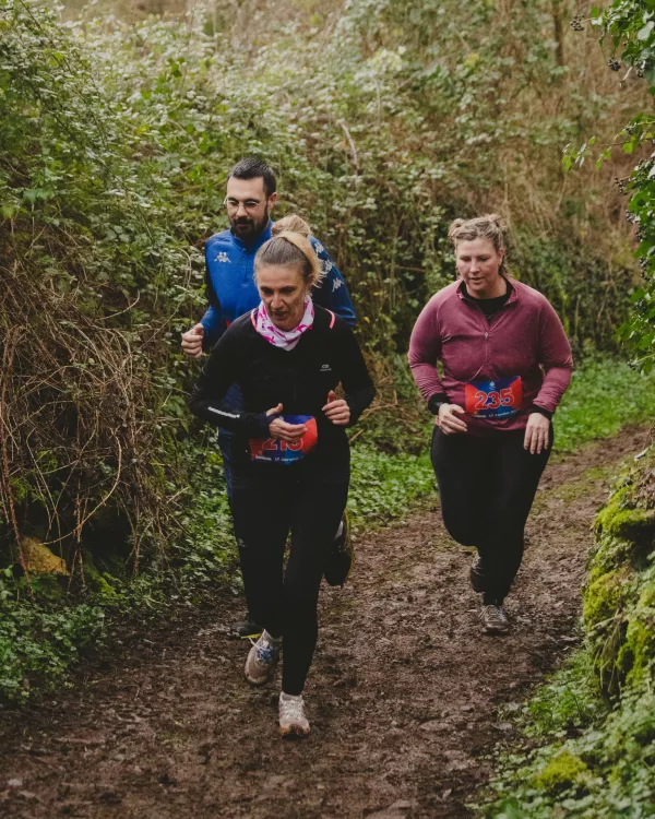 Coureurs dans un chemin creux boueux