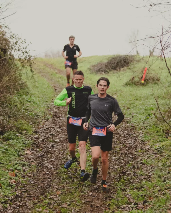 Coureurs sur un chemin herbeux entre les haies